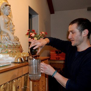 Cesara, a guest at the Abbey, emptying water bowls.