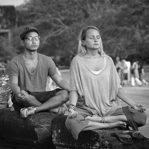 Man and woman meditating outside.