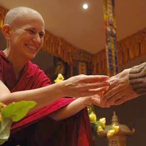 Venerable Chodron giving mani pills to a retreatant.