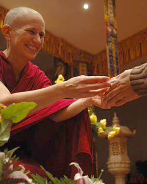 Venerable Chodron giving mani pills to a retreatant.