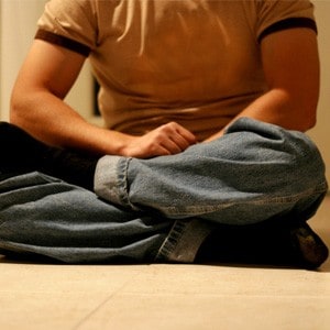 Young man sitting in meditation posture.