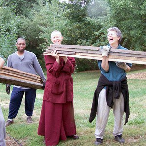 Venerable Tarpa, Zopa, and Frederick cleaning up materials from the construction of Gotami House.