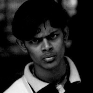 Black and white closeup of young man's face, looking angry.