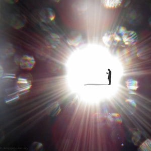 A man standing inside a very bright circle of light.