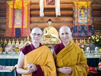 Venerable Chonyi standing by Venerable Chodron in the Abbey mediation hall.