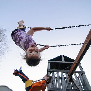 Children swinging and smiling.