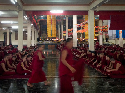 Many monks in a large hall at Drepung Monastery.