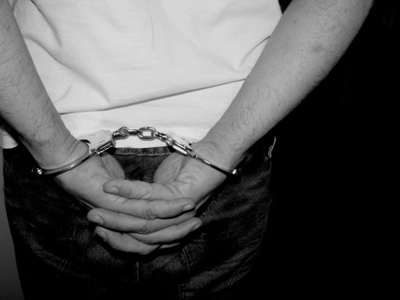 A man's handcuffed hands behind his back.