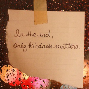 A paper with the wordings: In the end, only kindness matters, stick on window with raindrops.