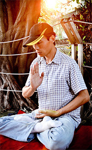 A man sitting outside, meditating.