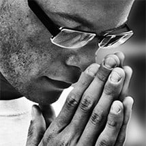 A man with head bowed in prayer.