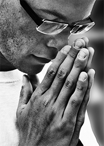A man with head bowed in prayer.