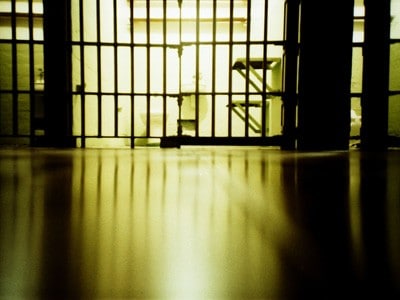 Prison cell in dim light.