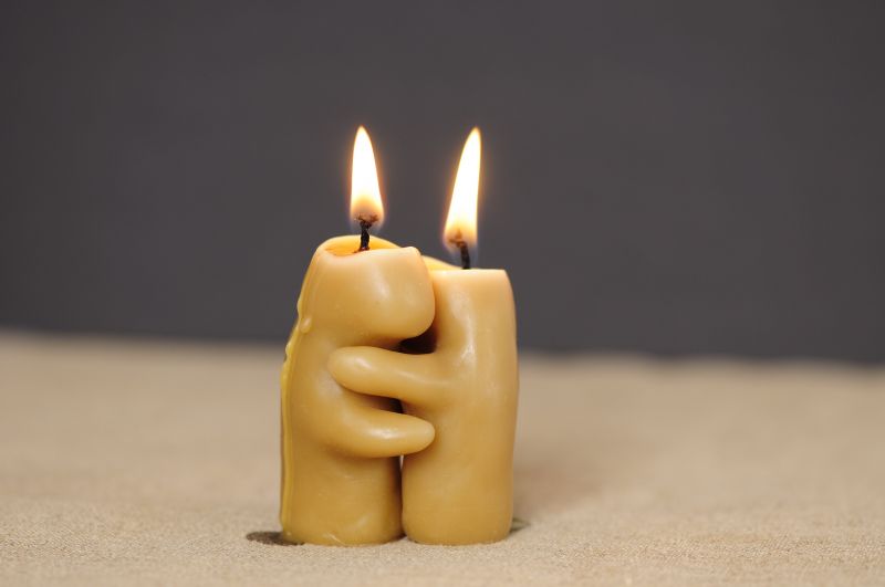 Two candles hugging as they burn down