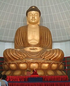 Venerable Chodron giving a talk in front of the large Buddha statue at Phor Kark See Monastery in Singapore.