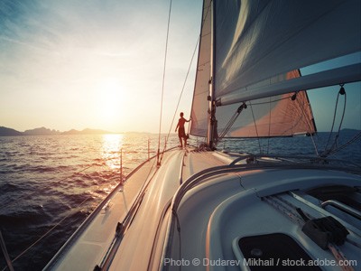 Man standing at the bow of a yacht.