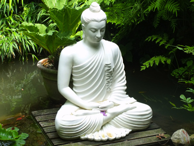 Statue near a lotus pond of a Buddha in meditation.
