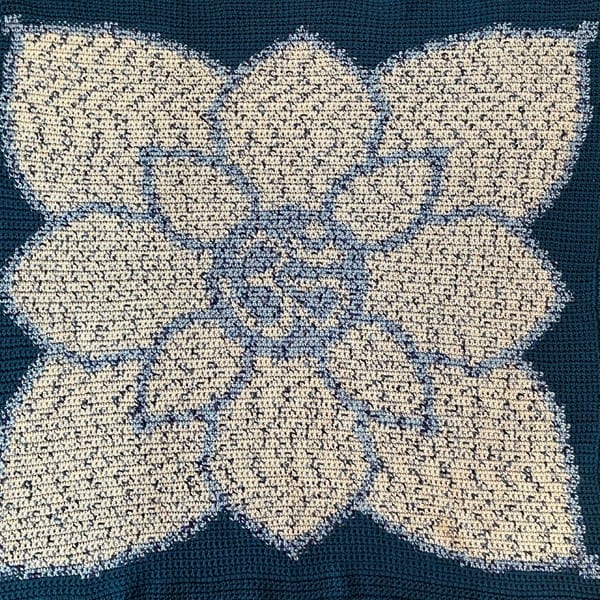 A hand-made blue blanket with a white lotus in the center.