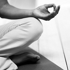 Closeup of a leg and hand of person in sitting meditation.