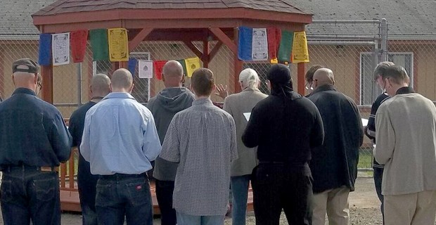 Inmates standing around a new pagoda on the prison ground.