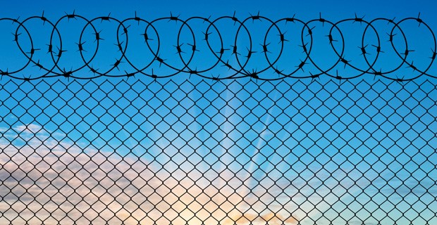 Prison wire against blue sky.