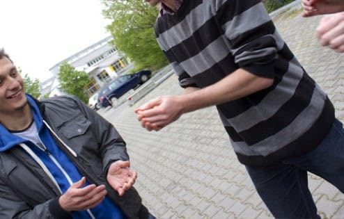 Two young men passing a hot potato.