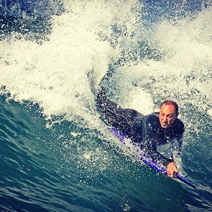 Man surfing on a boogie board.