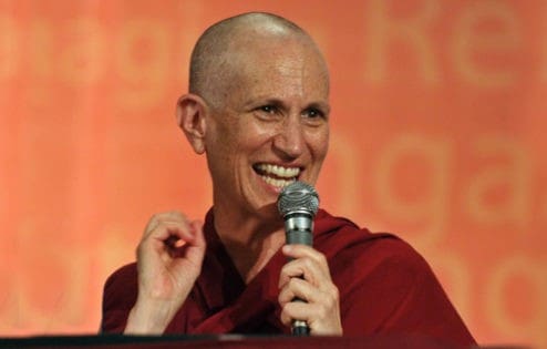 Venerable holding a microphone and smiling.