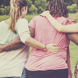 Women with arms around each other in support.