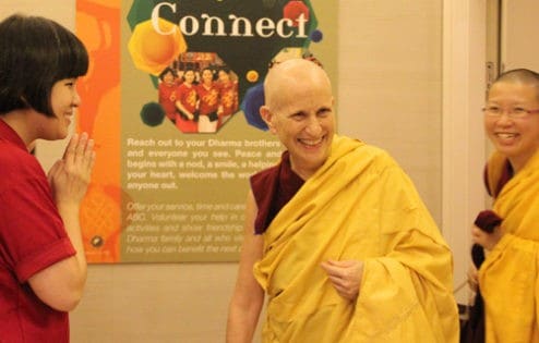 Ven. Chodron smiling and entering the centre with Ven. Damcho.