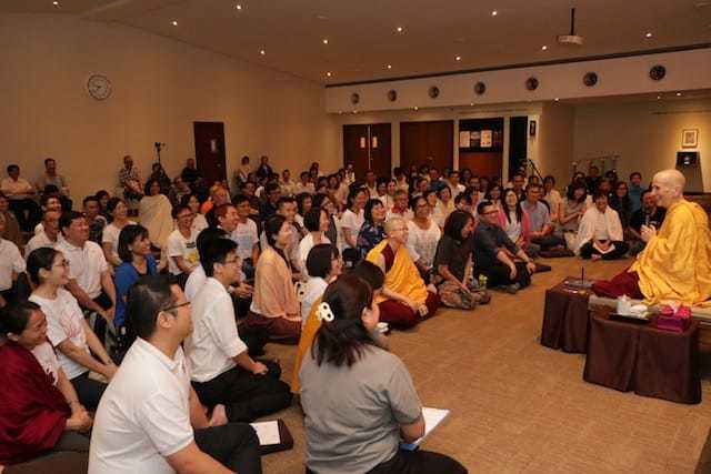 Venerable teaching in front of a large crowd at Nalanda Buddhist Centre.