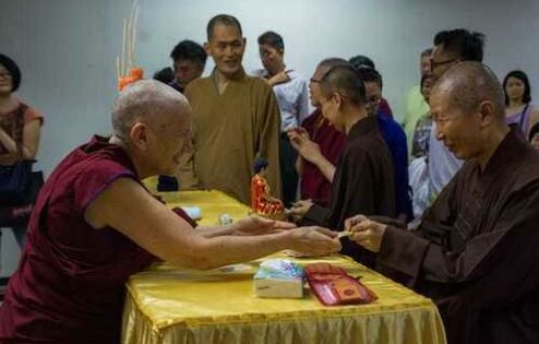 Venerable making a hand gesture while teaching.