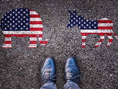 Shoes on asphalt road with elephant and donkey painted on road.