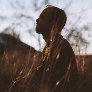 Silhouette of man sitting in meditation in country meadow.