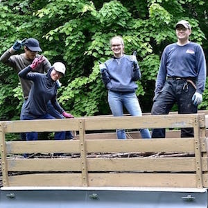 Four young adults smiling in the back of a pickup truck.