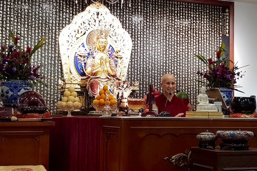 Ven. Chodron sits and teaches in front of a Maitreya statue at Vimalakirti Buddhist Centre Singapore.