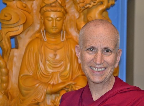 Venerable Chodron in front of the wooden Kuan Yin statue in Chenrezig Hall.