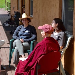 A nun and two laypeople sitting in a discussion circle.