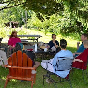 Young people and a monastic sitting in a discussion circle.