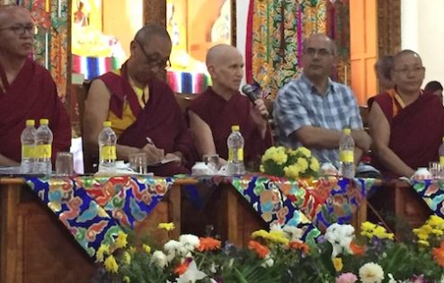 Venerable sitting with a group of panelists, speaking.