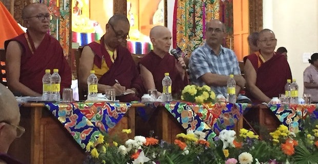 Venerable sitting with a group of panelists, speaking.