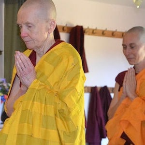 Venerable Khadro standing with head bowed and palms together.