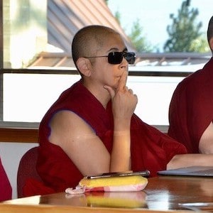 Venerable Nyima wearing sunglasses while listening to a teaching.