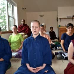 Monastics, lay trainees, and lay people sit in meditation at Sravasti Abbey.