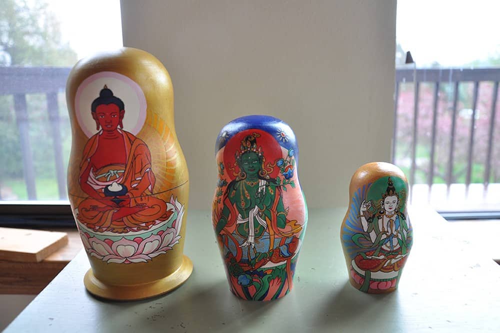 Three Russian dolls with Amitabha, Green Tara, and Vajrasattva painted on them.