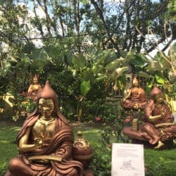 Statues of great Indian pandits in an outdoor garden.