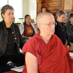 Venerable Jigme and lay people sit in meditation in the Sravasti Abbey Meditation Hall.