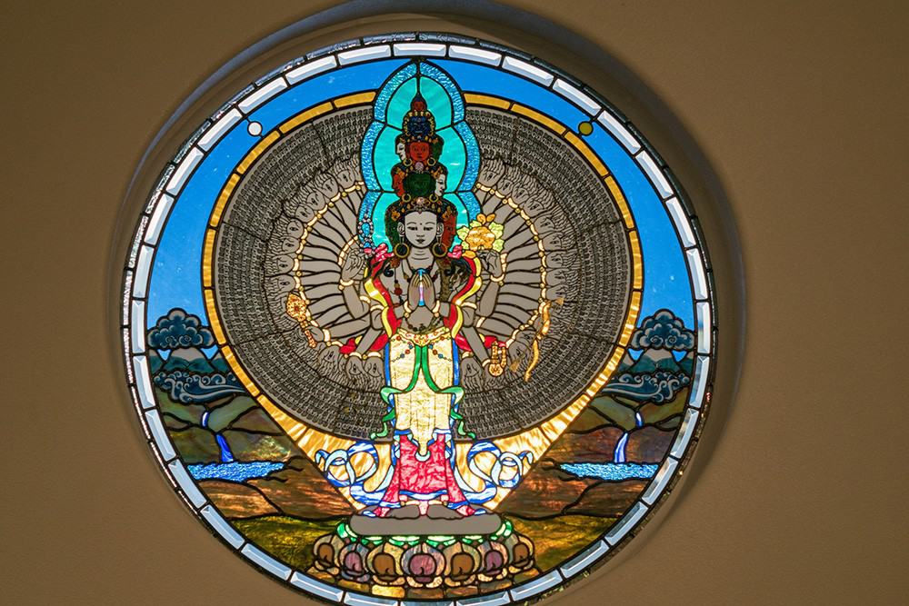 Stained-glass window of thousand-armed Chenrezig.