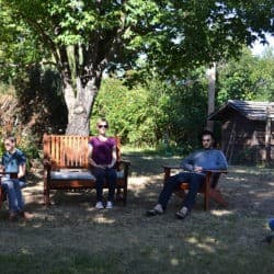 Lay people sit in chairs in the Sravasti Abbey garden in meditation.