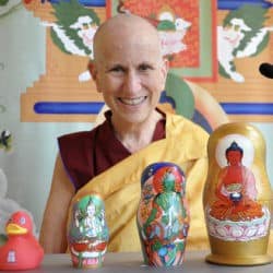 Venerable Thubten Chodron with three Russian dolls with Buddhas painted on them and a red rubber duck.